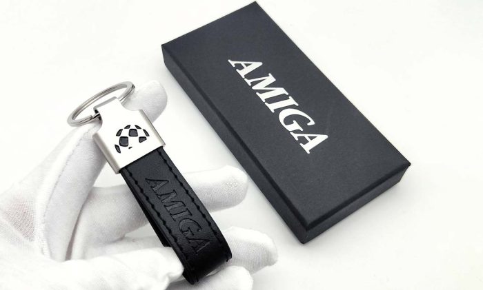 Classic Amiga logo keychain with leather strap, displayed in front of its packaging